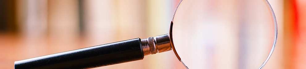 A magnifying glass on a wooden floor.